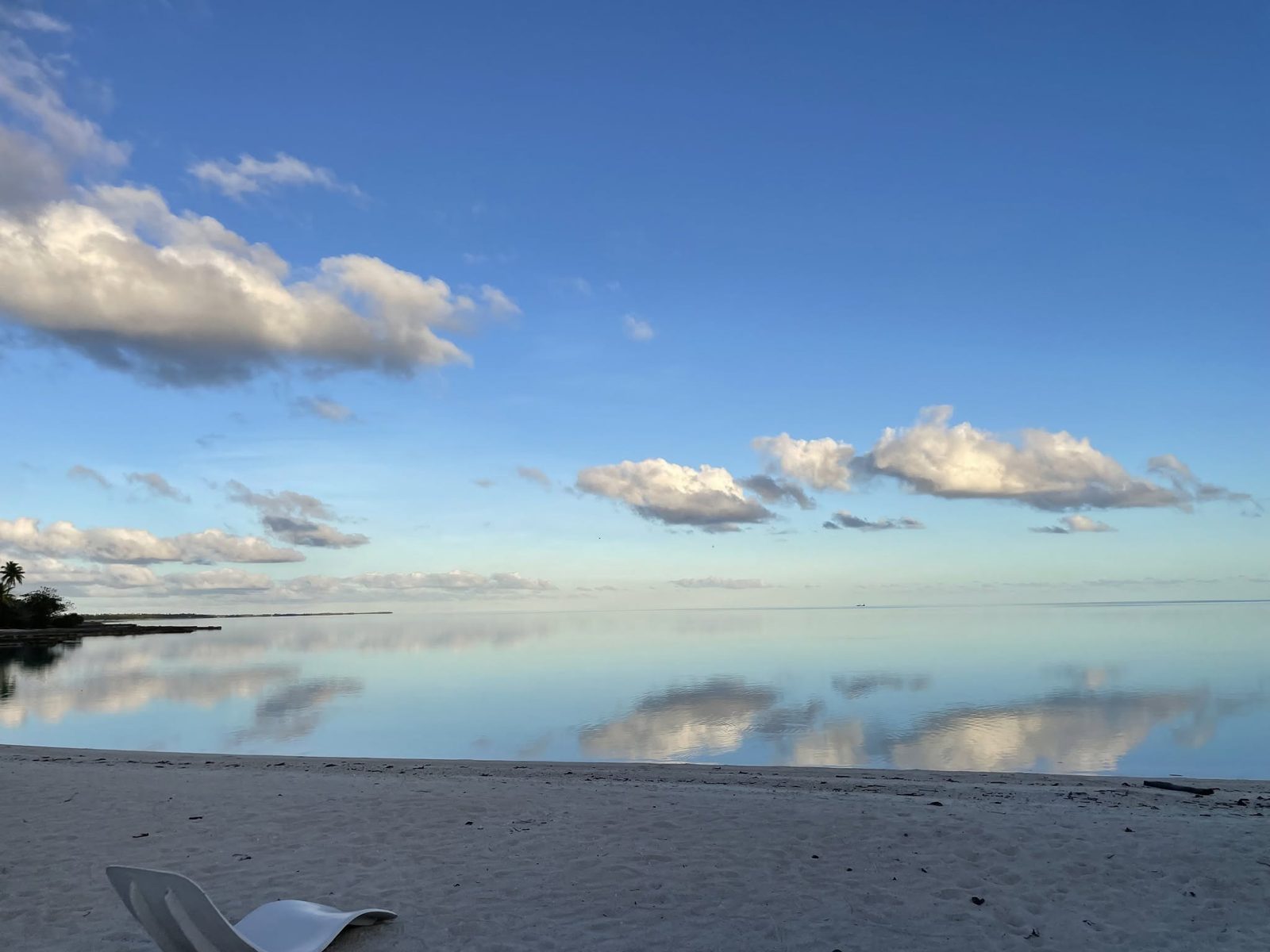 Lagon de Makemo, lisse comme un miroir, reflétant le ciel et les nuages